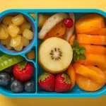 Alt Text: Healthy kids' lunchbox image featuring chicken wraps, vegetables, and fruit (Healthy Lunchbox Recipes for Kids)